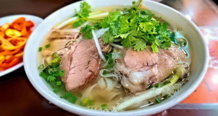 Kom traditionele Vietnamese pho met verse kruiden.
