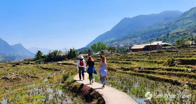 Mensen die langs een pad door rijstvelden lopen met een reiswaterlogo watermerk.
