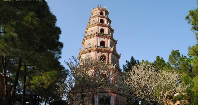 Historischer Pagoda-Turm umgeben von Bäumen.
