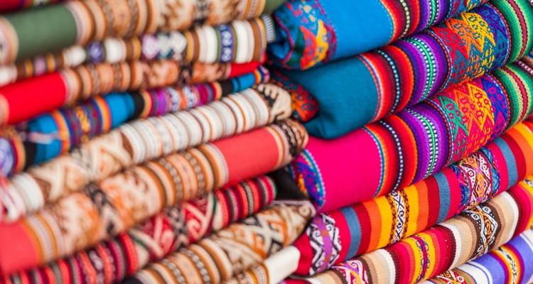 Textiles peruanos coloridos doblados y apilados.
