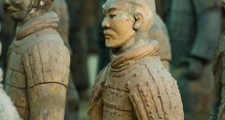 Primer plano de una estatua de Guerrero de Terracota mostrando detalles desgastados y expresión estoica.