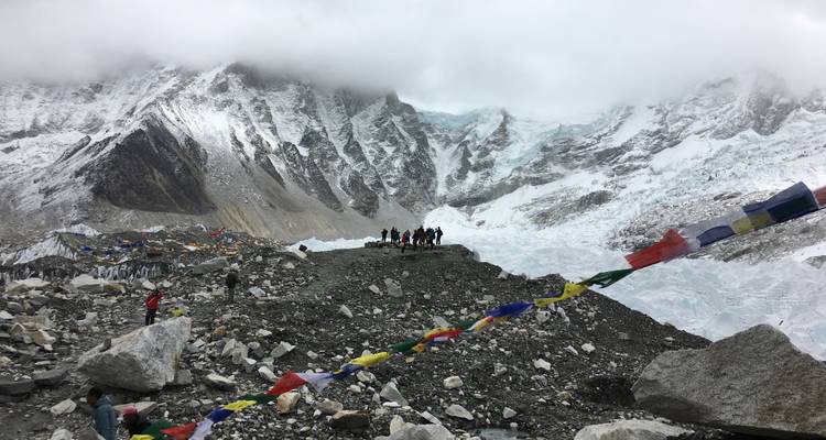 Hikers approaching a mountain covered with prayer flags.