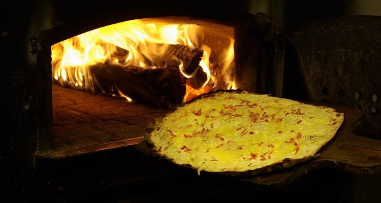 Elsässischer Flammkuchen wird in einem Holzofen gebacken