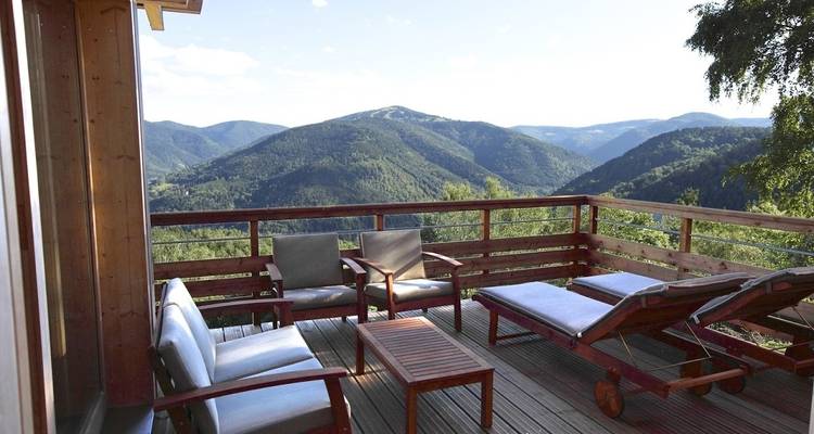 Holzdeck mit Sitzgelegenheiten und Bergblick