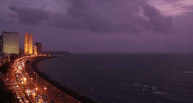 Vista crepuscular del Marine Drive de Mumbai con las luces de la ciudad reflejándose a lo largo de la costa del Mar Arábigo.