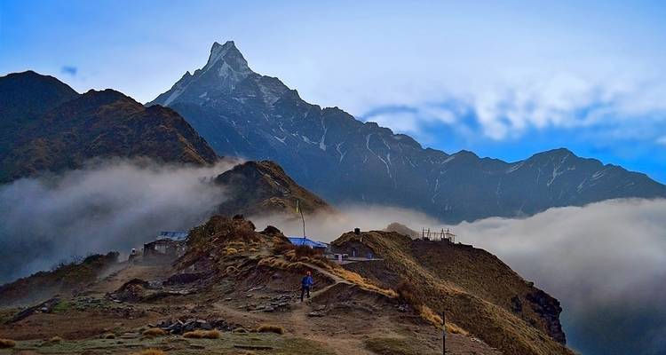 Mountains shrouded in mist under an evening sky with scattered clouds.