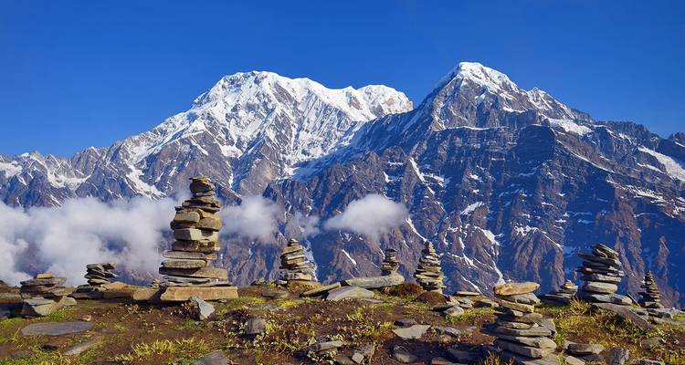 Stacked stones against the backdrop of towering mountains.