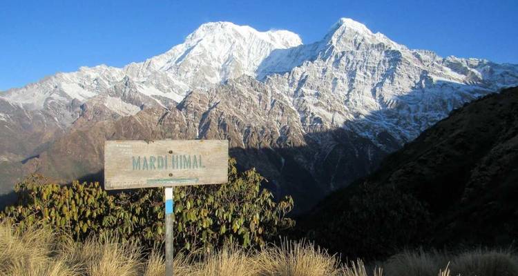 View of snowy peaks with a sign indicating Mardi Himal in foreground.