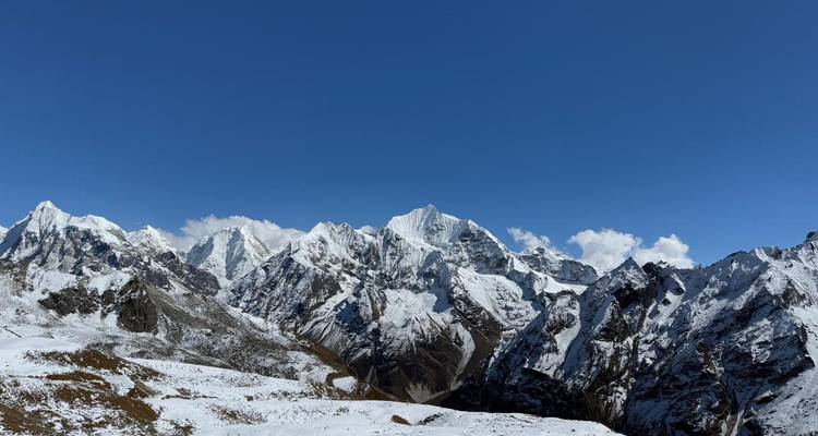 Dramatische, sneeuwbedekte Himalaya-pieken steken af tegen een diepblauwe hemel langs het Langtang-gebergte.