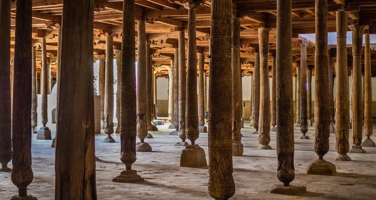Une grande salle avec des colonnes en bois.
