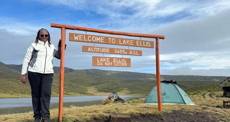 Een persoon bij een bord bij Lake Ellis.