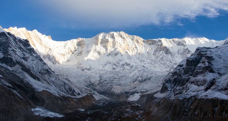 Chaîne de montagnes ensoleillée aux sommets enneigés.