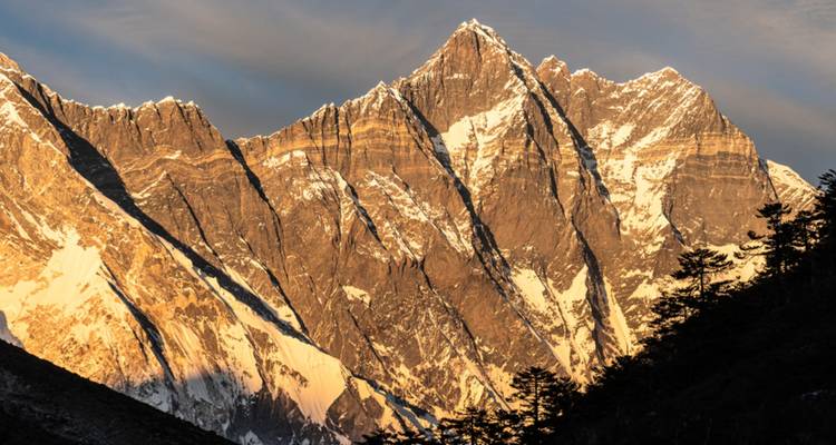 Pics escarpés dorés illuminés au lever du soleil.