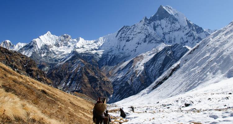Wanderer in einer bergigen verschneiten Landschaft.
