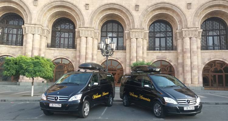 Tour vans parked in front of a historic building.