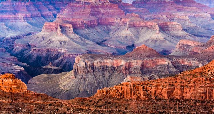 Layered ridges and mesas create a colourful geological tapestry in a panoramic view of the Grand Canyon.