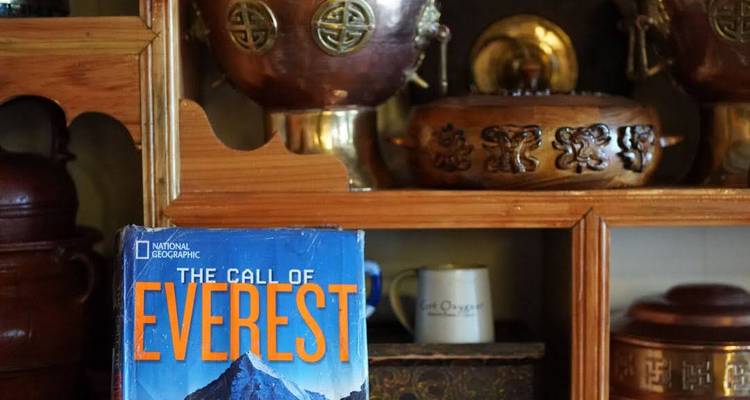 Bücherregal mit einem Everest-Buch und Kupferwaren.