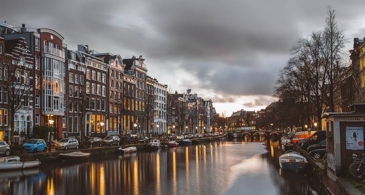Canal avec bâtiments historiques et bateaux à Amsterdam.