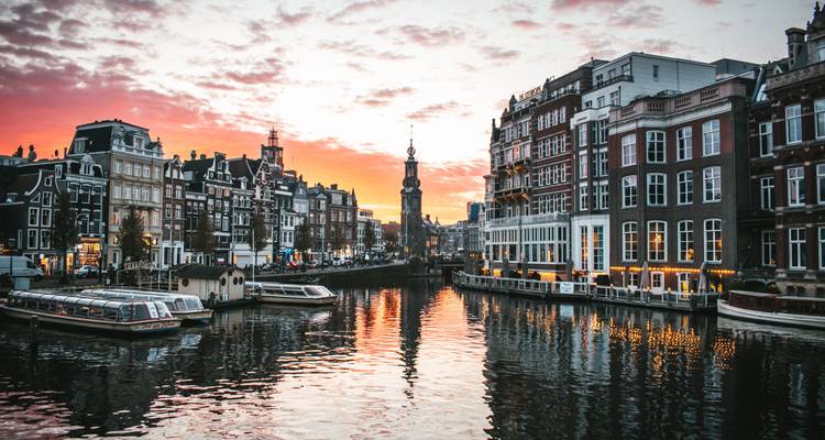 Canal à Amsterdam avec un ciel de coucher de soleil vibrant.