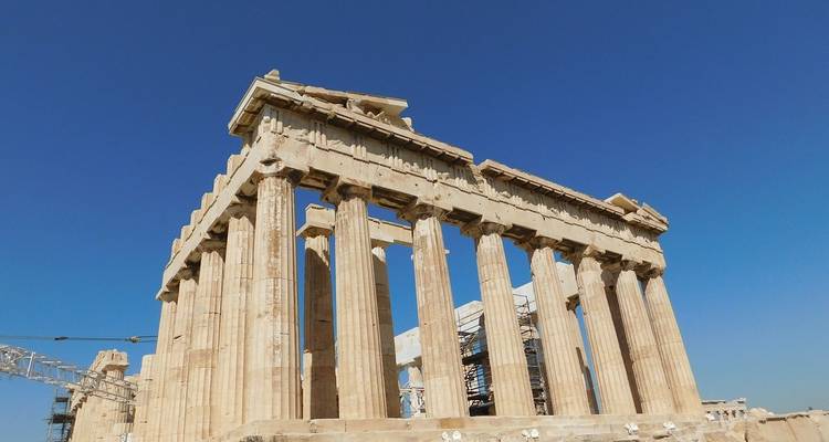 Primer plano de las columnas dóricas del Partenón contra un profundo cielo azul ateniense.
