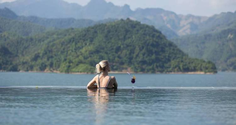 Person in a pool looking at a scenic mountain view.