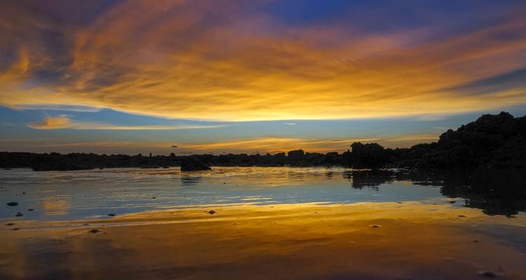 Prachtige zonsondergang met kleurrijke lucht en reflecties op het water.