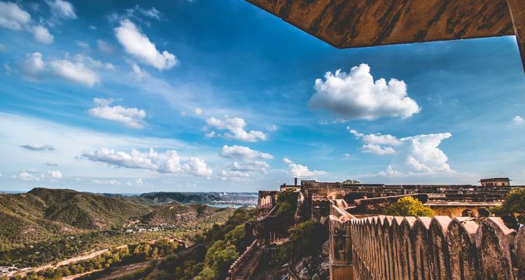 Panoramablick auf eine Festungsmauer, die sich in üppige Landschaften unter einem blauen Himmel erstreckt.