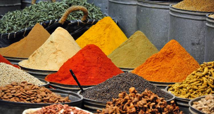 Haufen von bunten Gewürzen, die auf einem Markt ausgestellt sind.