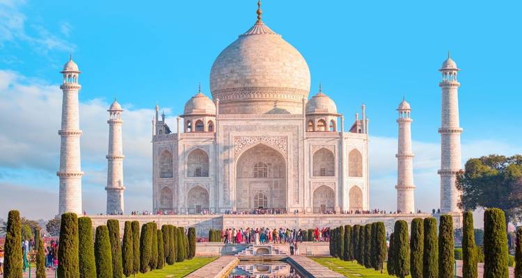 Vista majestuosa del Taj Mahal con cielo azul claro y jardines.