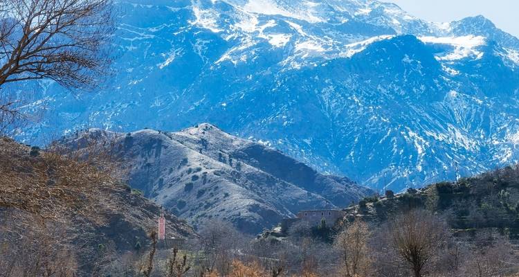 Bergachtig landschap met besneeuwde toppen in de verte.