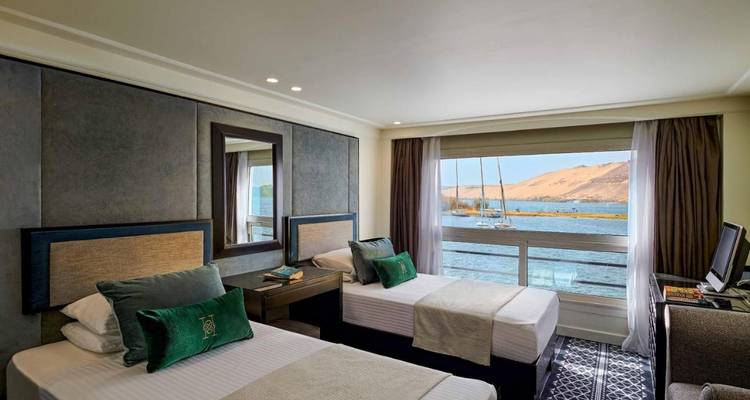 Chambre d'hôtel avec lits jumeaux donnant sur une rivière.