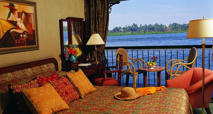 Chambre luxueuse sur un bateau de croisière avec vue sur la rivière.