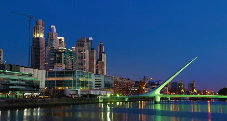 Night view of Puerto Madero district with illuminated bridge in Buenos Aires.