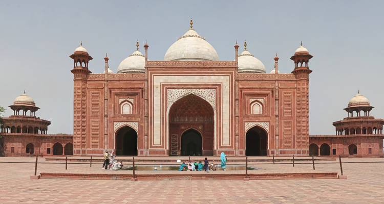Historic Mughal mosque with a central dome and smaller minarets.