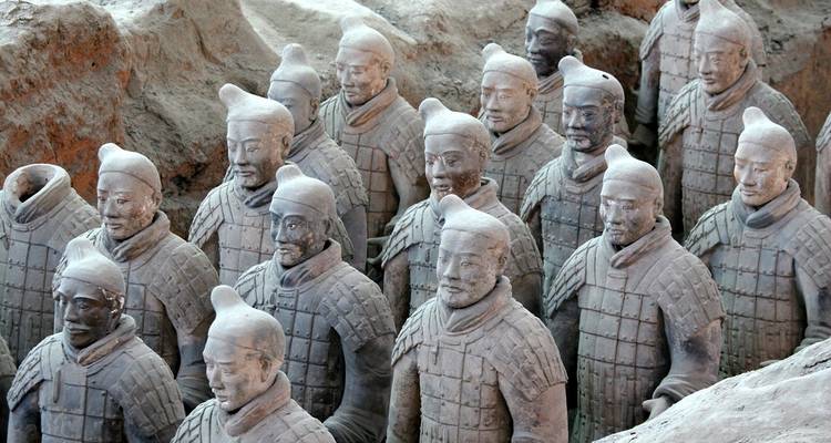 Here's the Dutch translation:
Terracotta leger standbeelden opgesteld in een archeologische vindplaats.
Alternative translation:
Terracotta leger standbeelden op een rij in een archeologische opgraving.