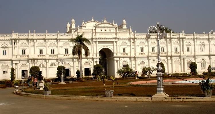 A grand white palace with intricate details and a central arched entrance.