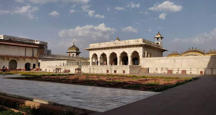 Grande cour avec bâtiments historiques et jardins.