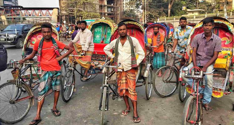 Rickshaw drivers standing beside their colorful rickshaws.