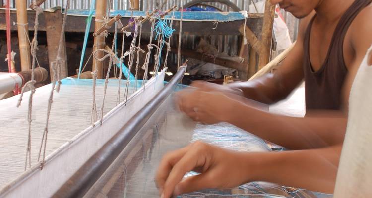 People working on a traditional weaving loom.