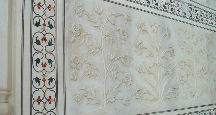 Een marmeren muur met ingewikkelde bloemengravures.