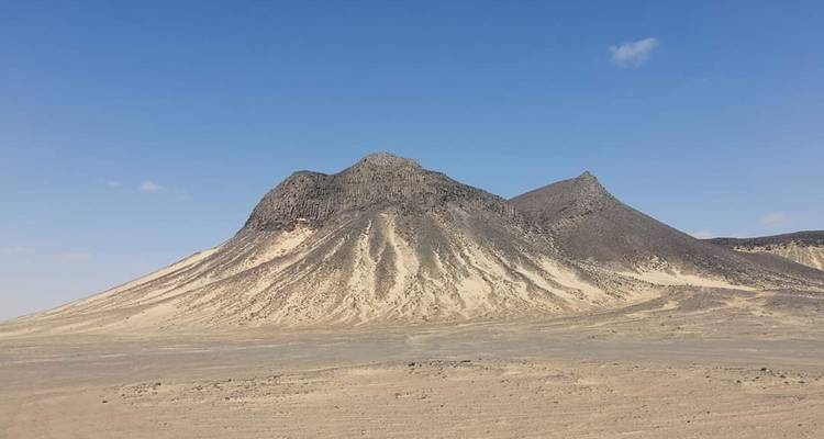 Berggipfel in einer Wüstenlandschaft unter einem klaren blauen Himmel.