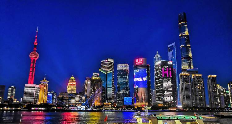 Vista nocturna vibrante del horizonte de Shanghái con rascacielos iluminados.