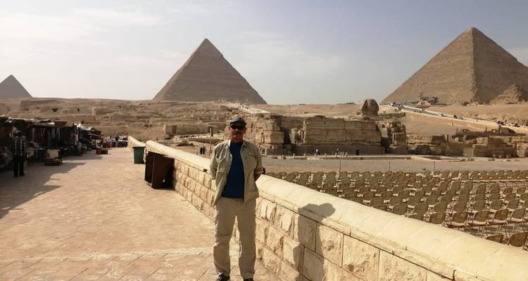 Person, die an einem sonnigen Tag vor Pyramiden posiert.