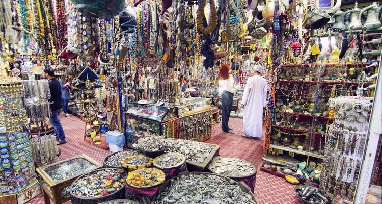 Belebter Markt mit verschiedenen Waren und Menschen.