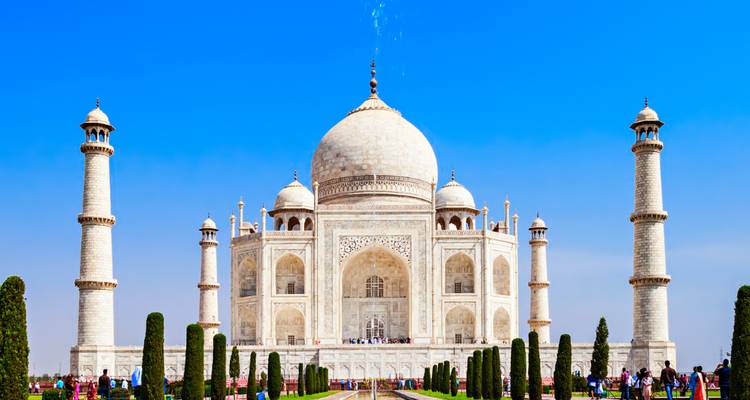 Le Taj Mahal par une journée claire avec des visiteurs au premier plan.