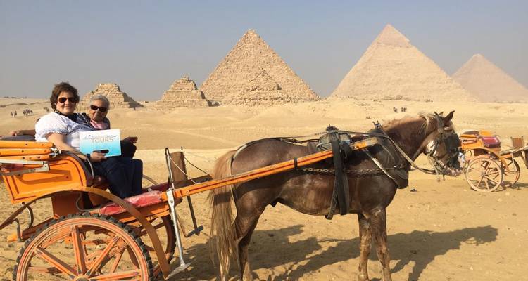 Paar in einer Pferdekutsche vor den Pyramiden.