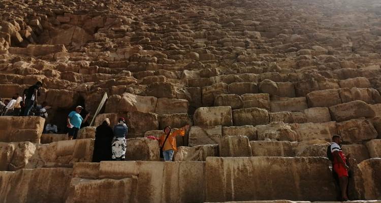Tourists exploring the stone steps of an ancient structure.