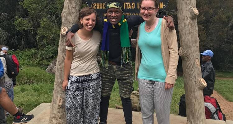 Drei Personen lächeln und posieren für ein Foto bei einer Naturattraktion.