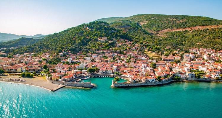 Luchtfoto van een kustplaats met heuvels op de achtergrond.