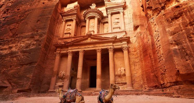Fassade des Schatzhauses von Petra mit Kamelen, die davor sitzen.